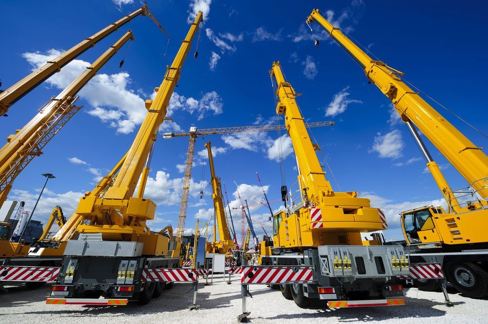 Row of Yellow Construction Cranes Are Parked in a Parking Lot — Barkly Hire in Ryan, QLD