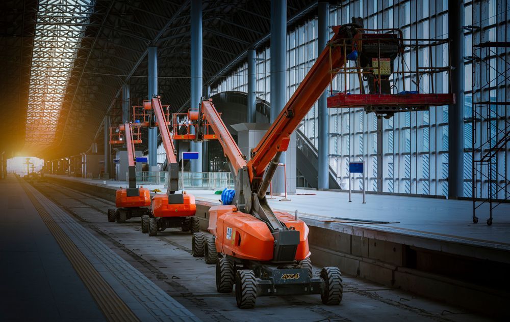 Row of Orange Aerial Lifts Are Parked in Front of a Building — Barkly Hire in Ryan, QLD