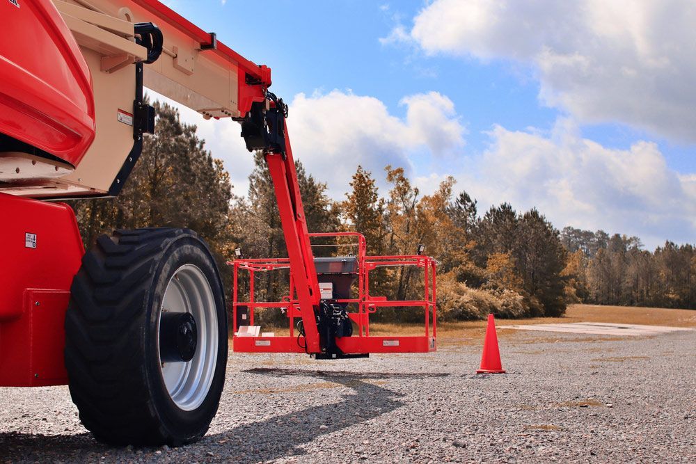 Red Lift is Parked on the Side of the Road Next to an Orange Cone — Barkly Hire in Ryan, QLD