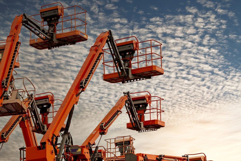 Group of Orange Aerial Lifts Against a Cloudy Sky — Barkly Hire in Ryan, QLD