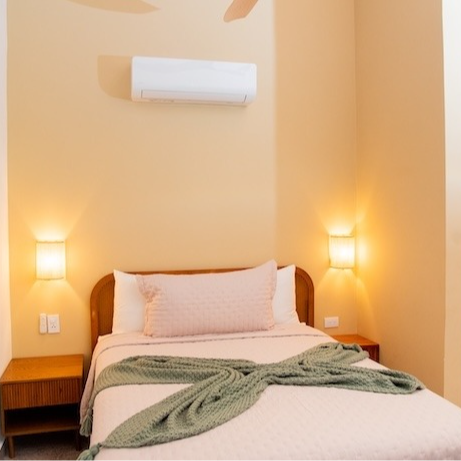 A bedroom with a bed and a ceiling fan