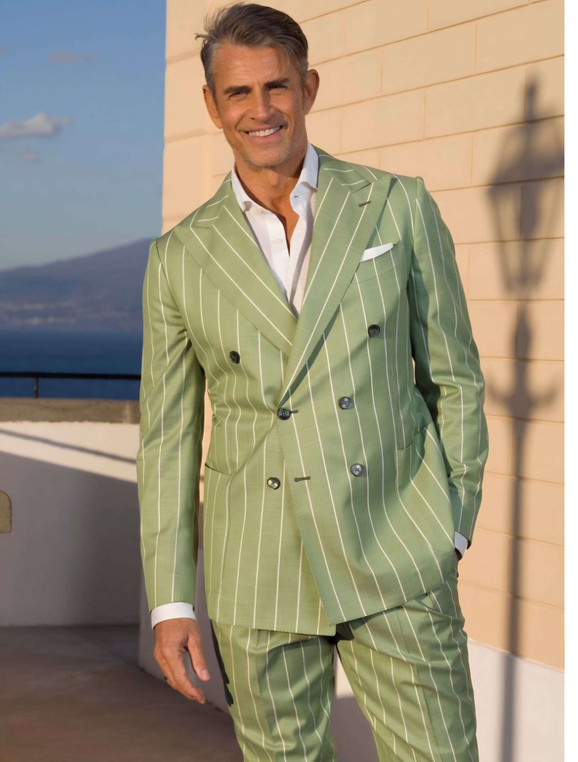 A man in a green striped suit is standing in front of a building