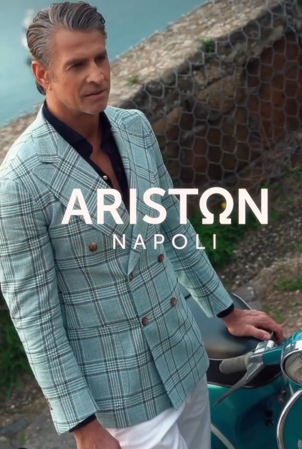 A man in a suit is standing next to a scooter.