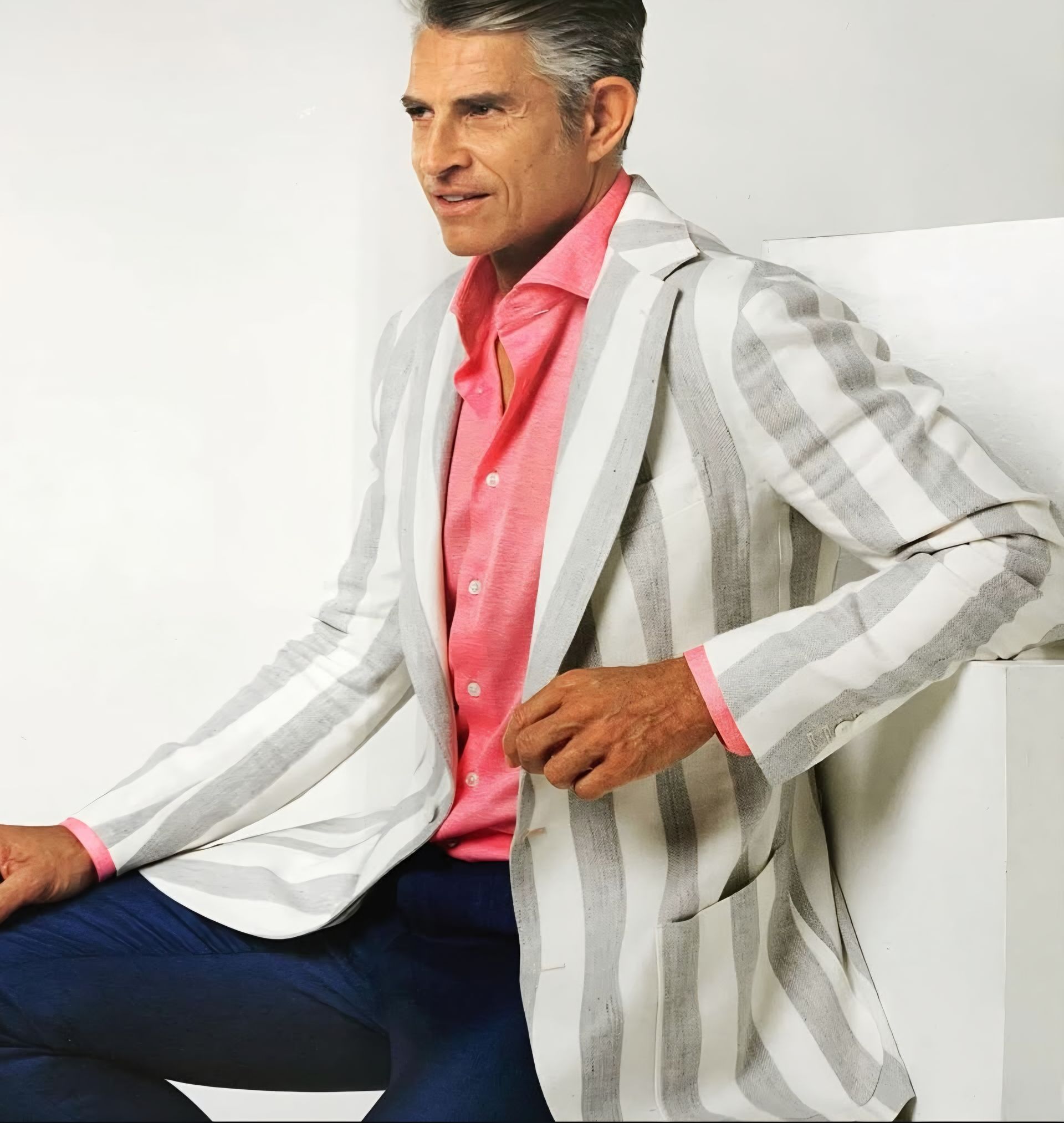 A man wearing a striped jacket and a pink shirt