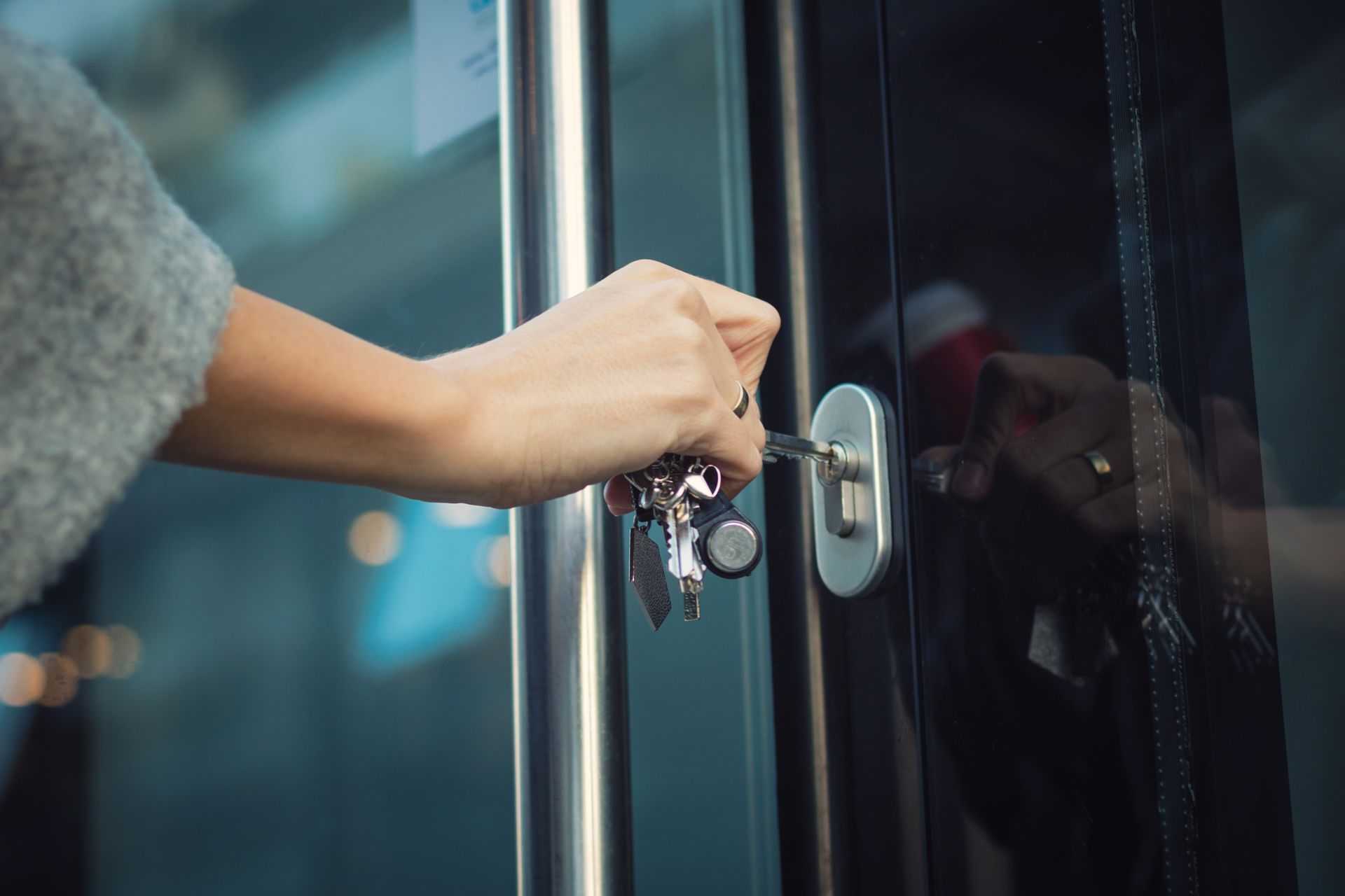 A woman is opening a door with a key.