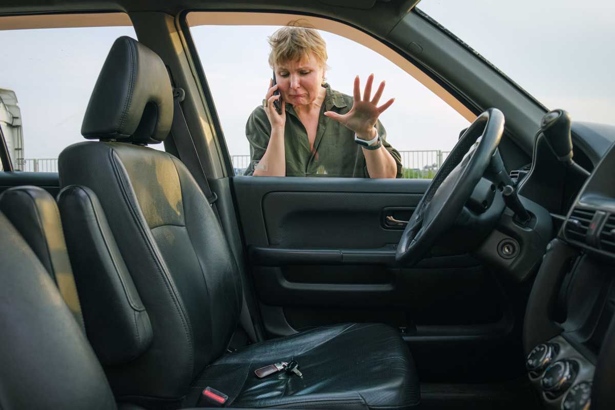 A woman is sitting in a car talking on a cell phone.