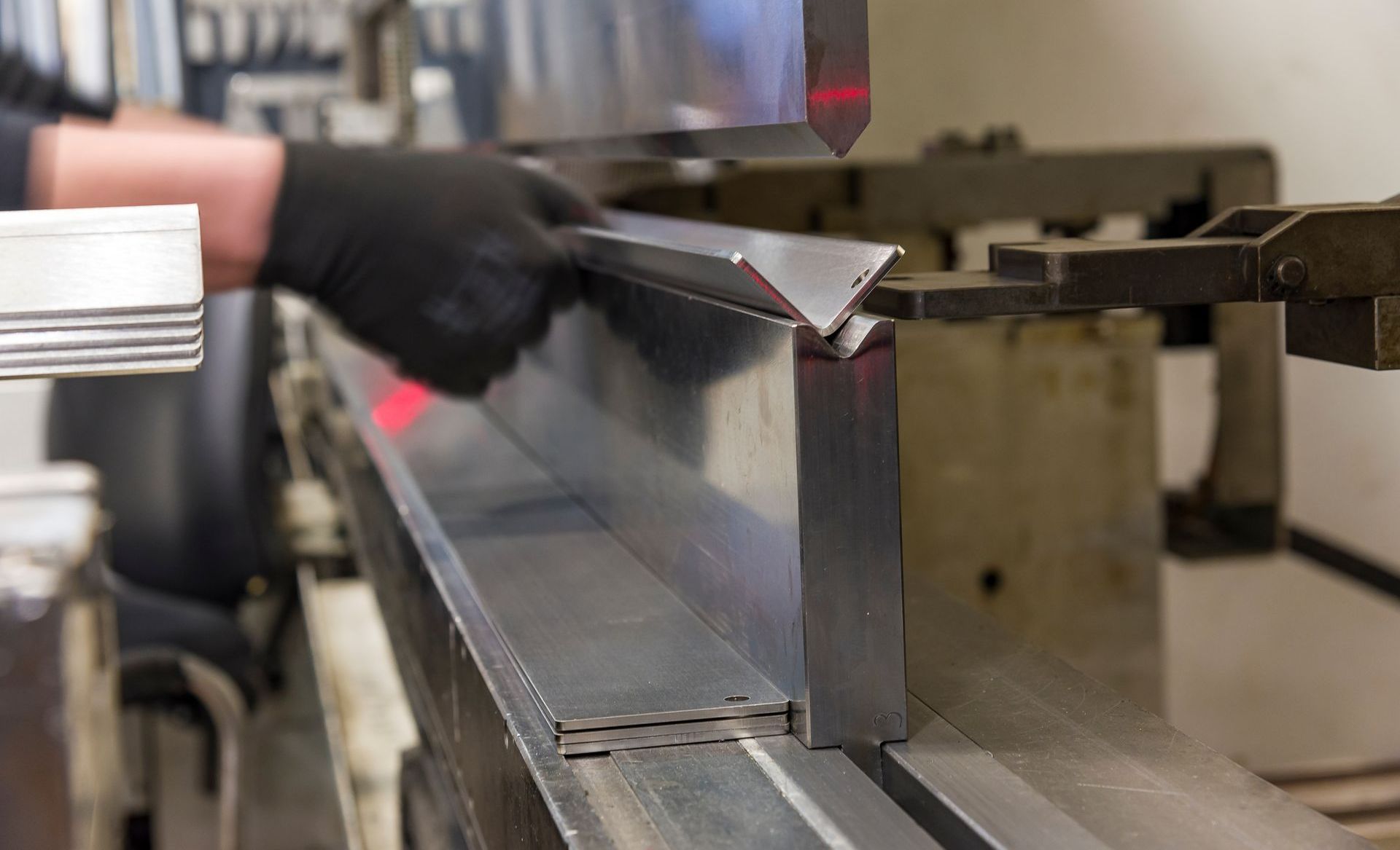 Une personne utilise une machine pour plier un morceau de métal.