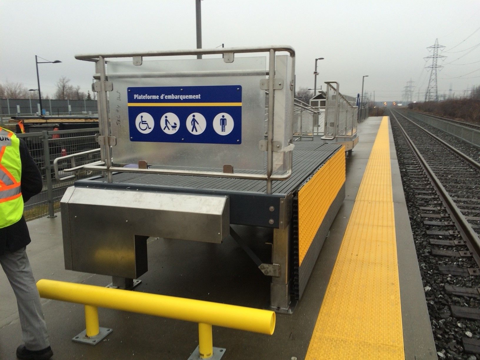 Un homme en gilet jaune marche vers une gare