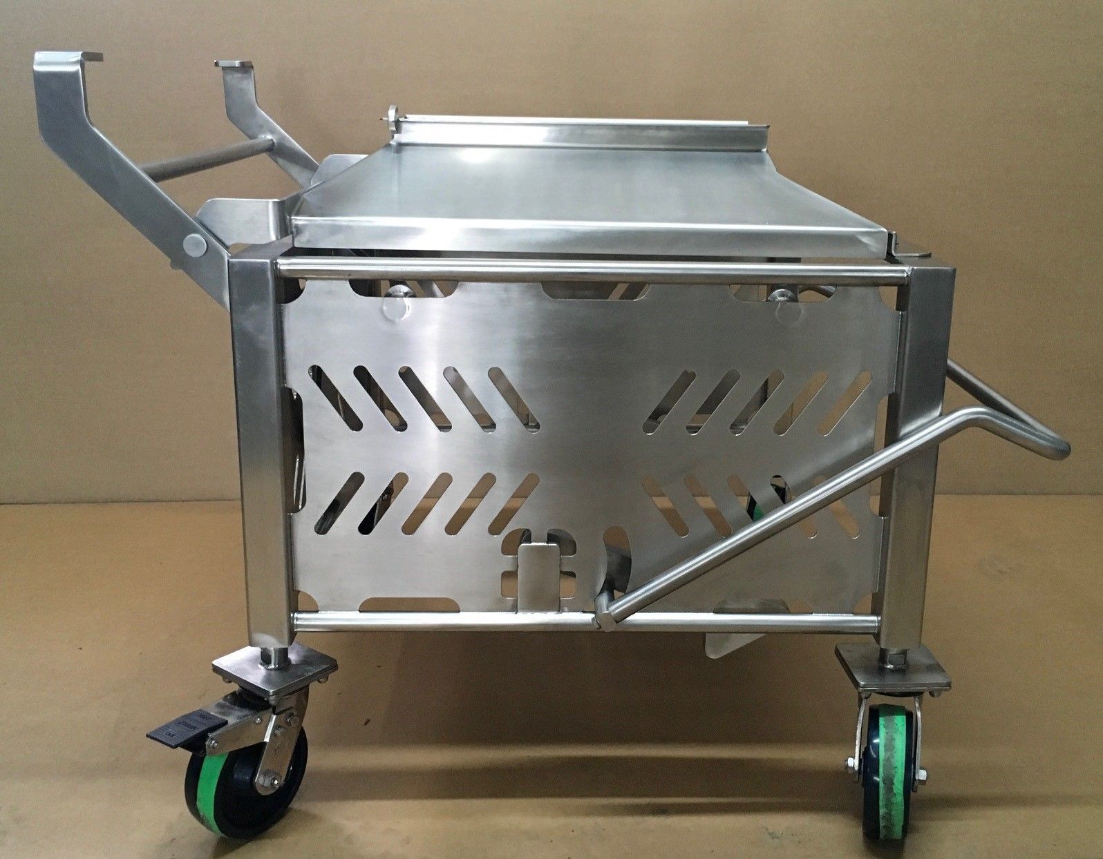 Un chariot en acier inoxydable avec des roues vertes et une poignée