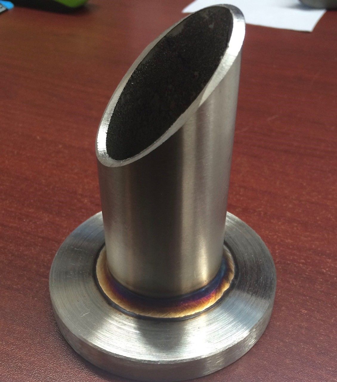 Un tuyau en acier inoxydable est posé sur une table en bois