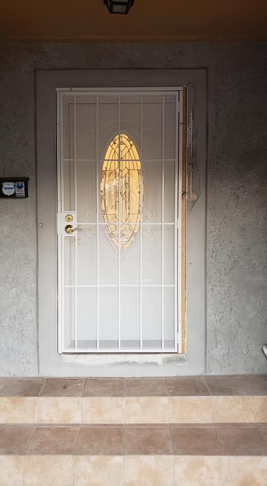 White security door with oval stained glass panel, set within a gray concrete frame.