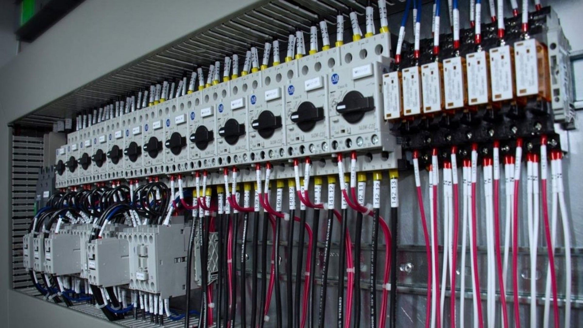 Un panel eléctrico grande con muchos cables colgando de él.
