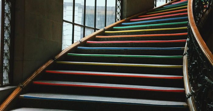 a grand staircase with red stair carpet design by Custom Stairs Orlando