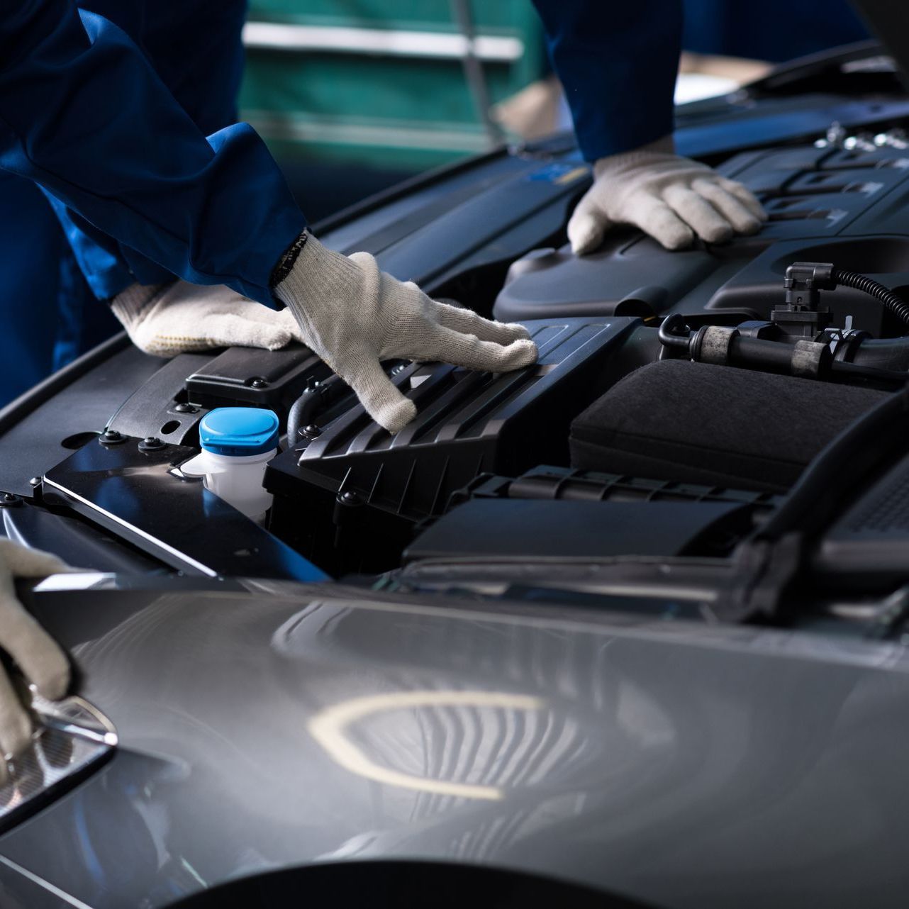 A person is working on the engine of a car