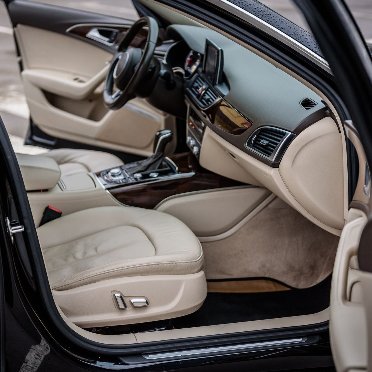 The interior of a black car with the door open