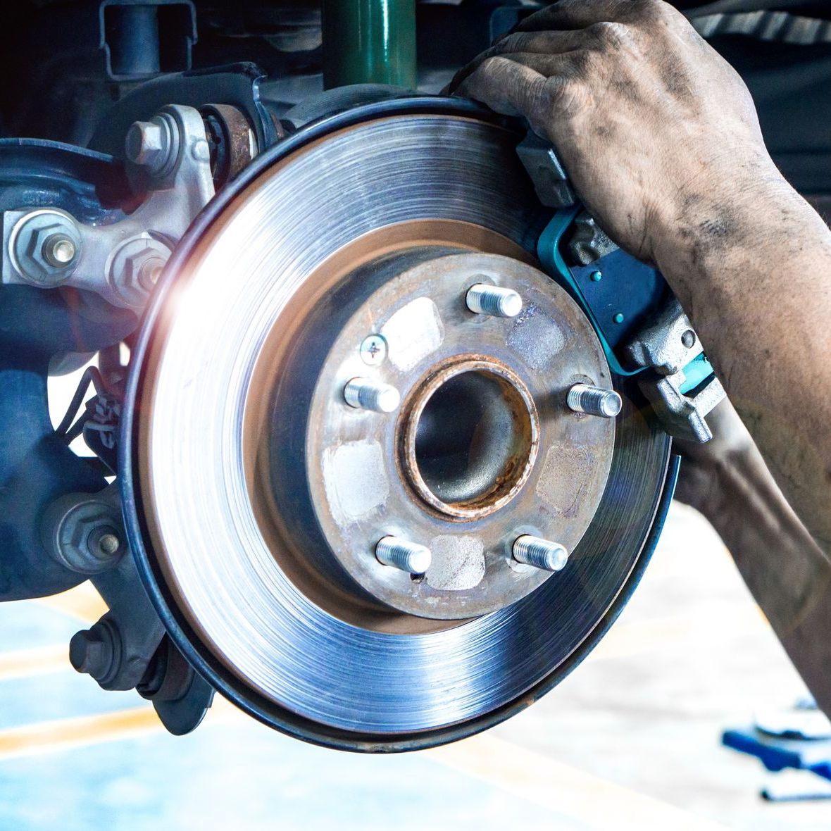 A person is working on a brake disc on a car.