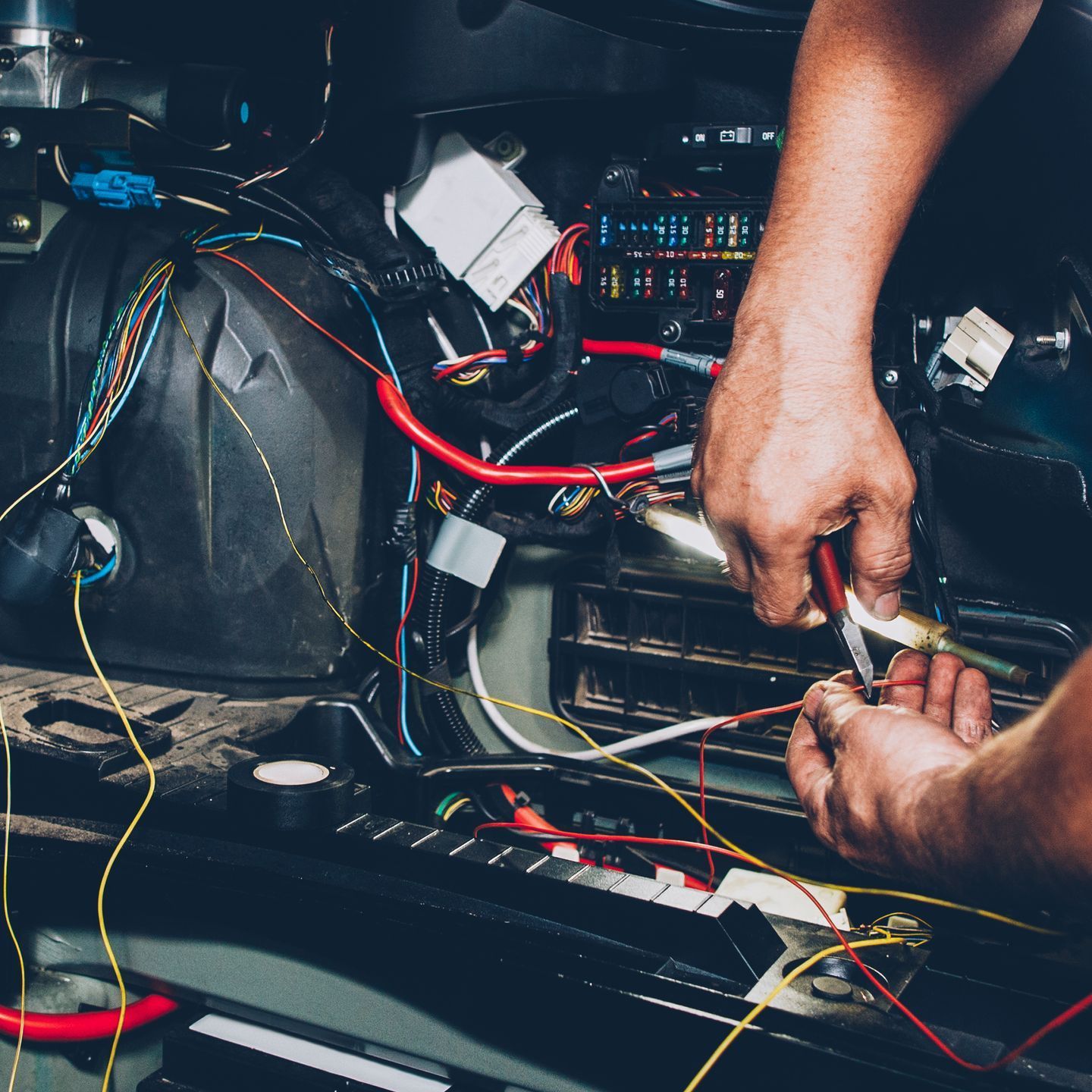 A man is working on the engine of a car.