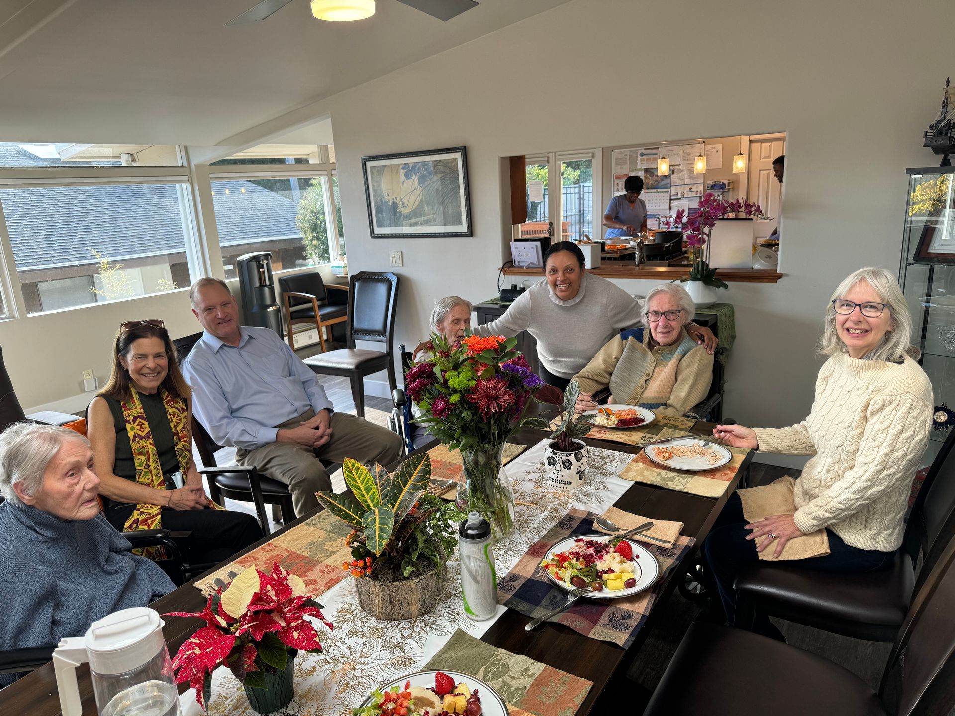 A group of people are sitting around a table with plates of food.