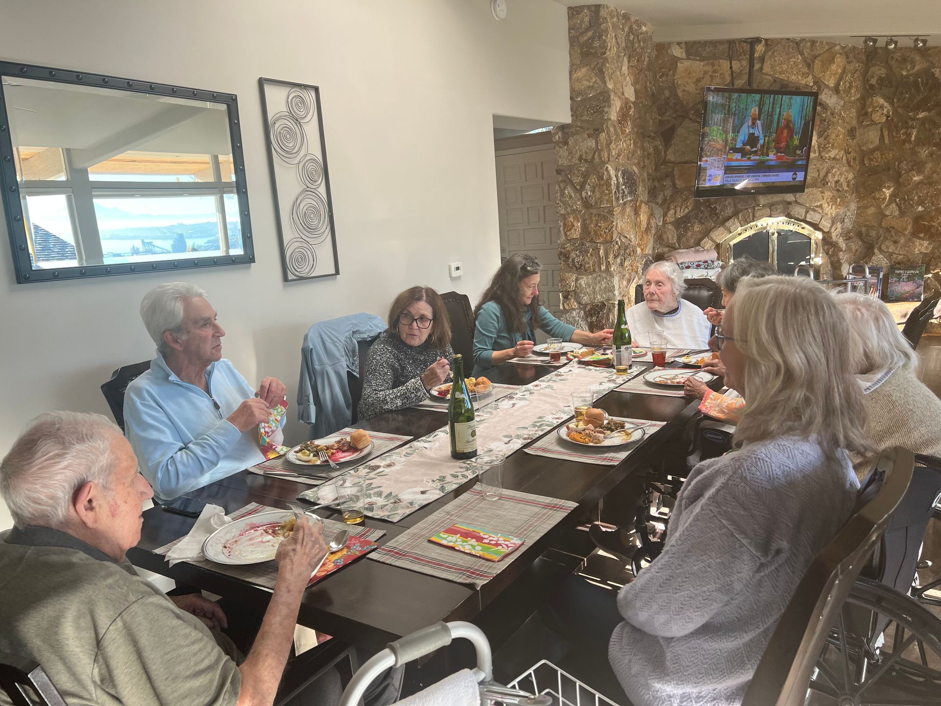 A group of people are sitting at a long table eating food.