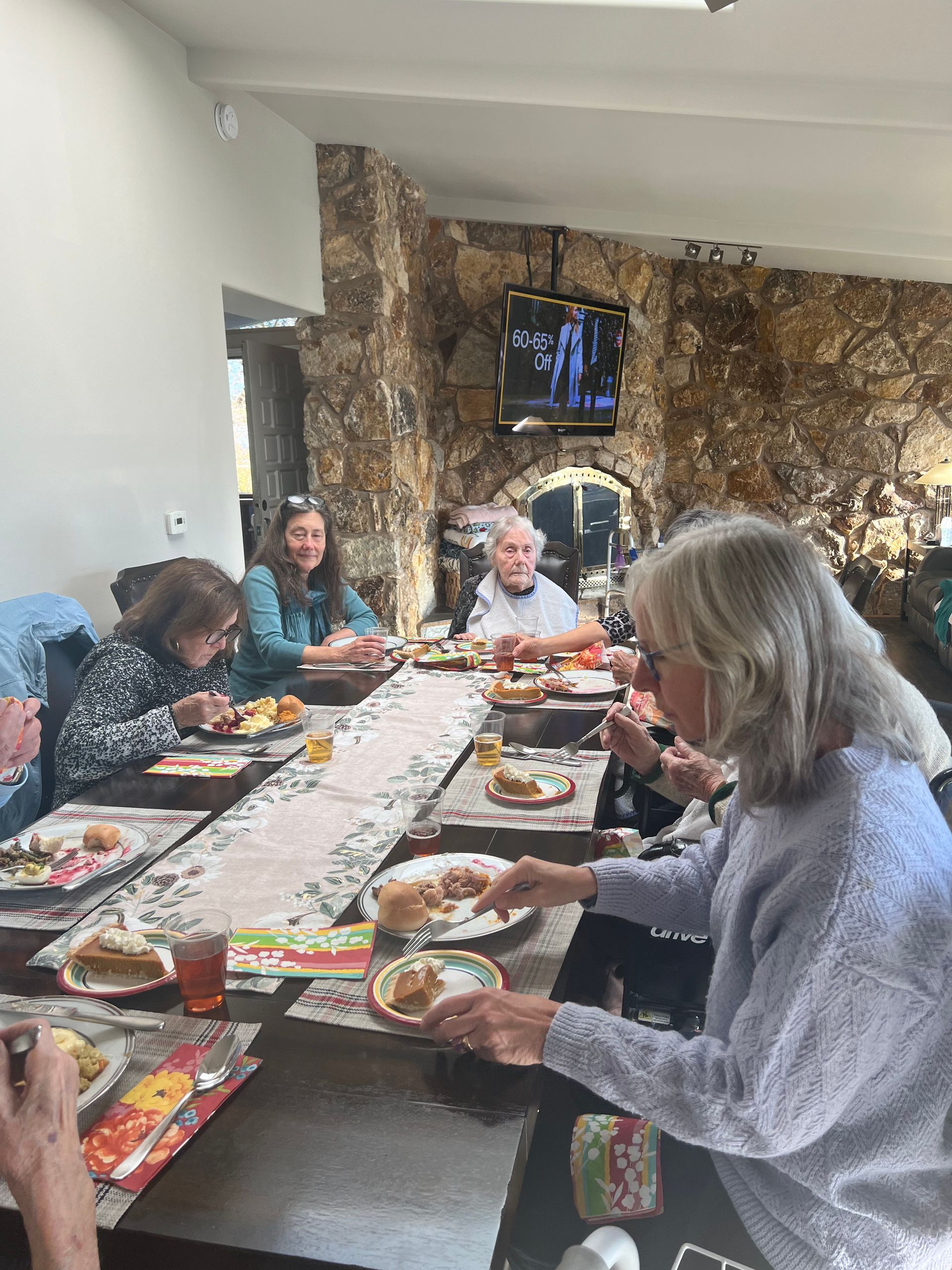A group of people are sitting at a long table eating food.
