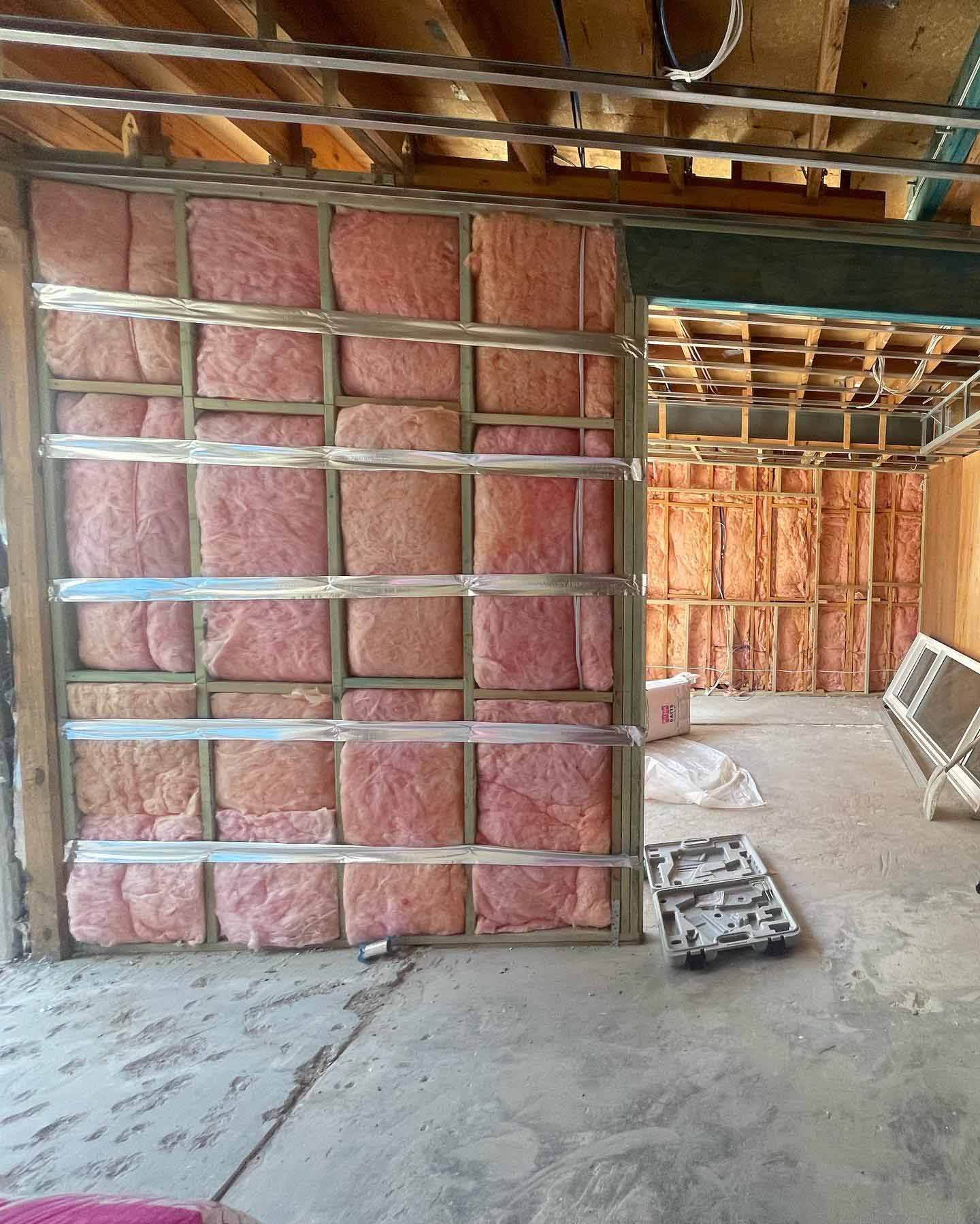 A room under construction with a wall covered in insulation — Home Insulation in Lismore NSW