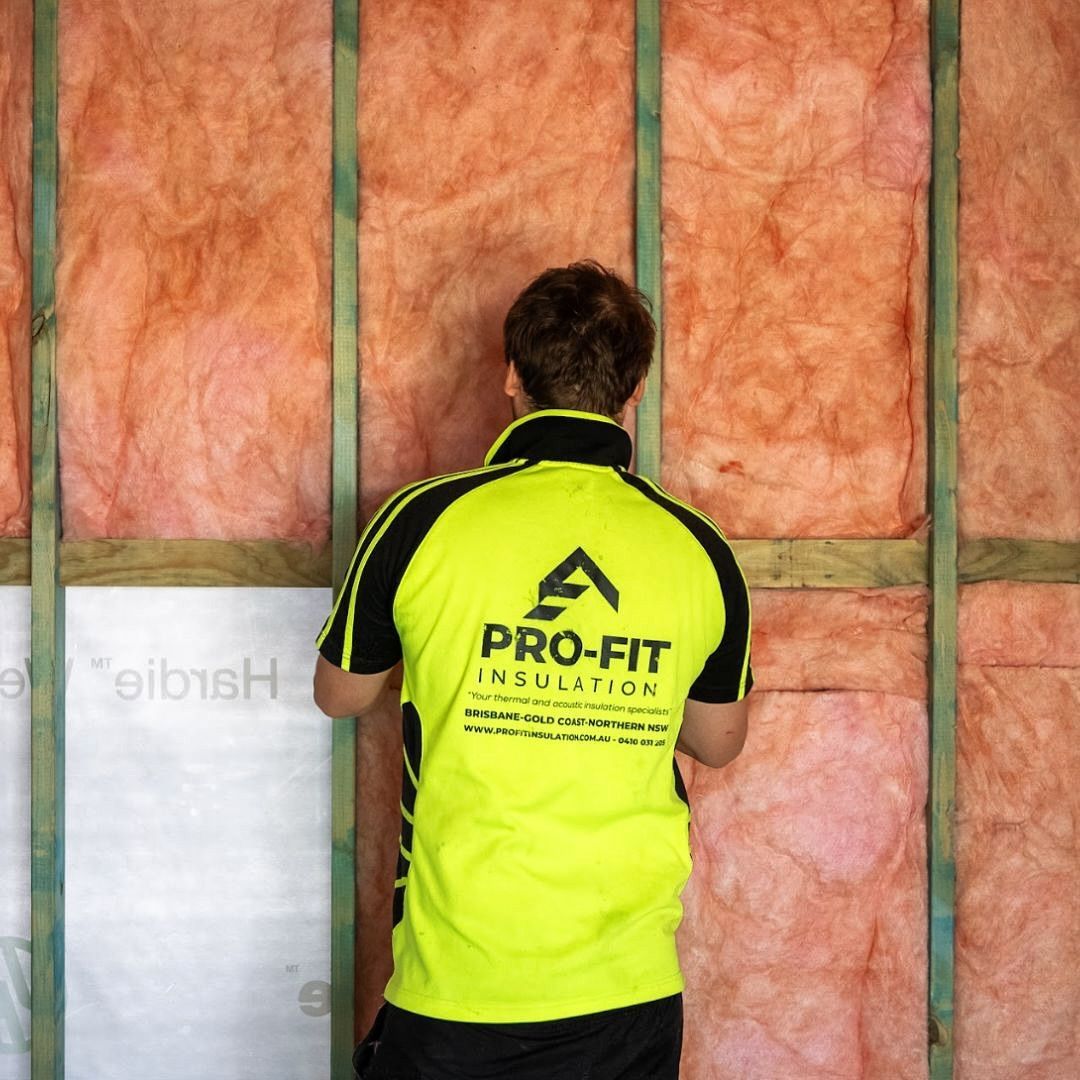 A man wearing a yellow shirt that says pro-fit insulation