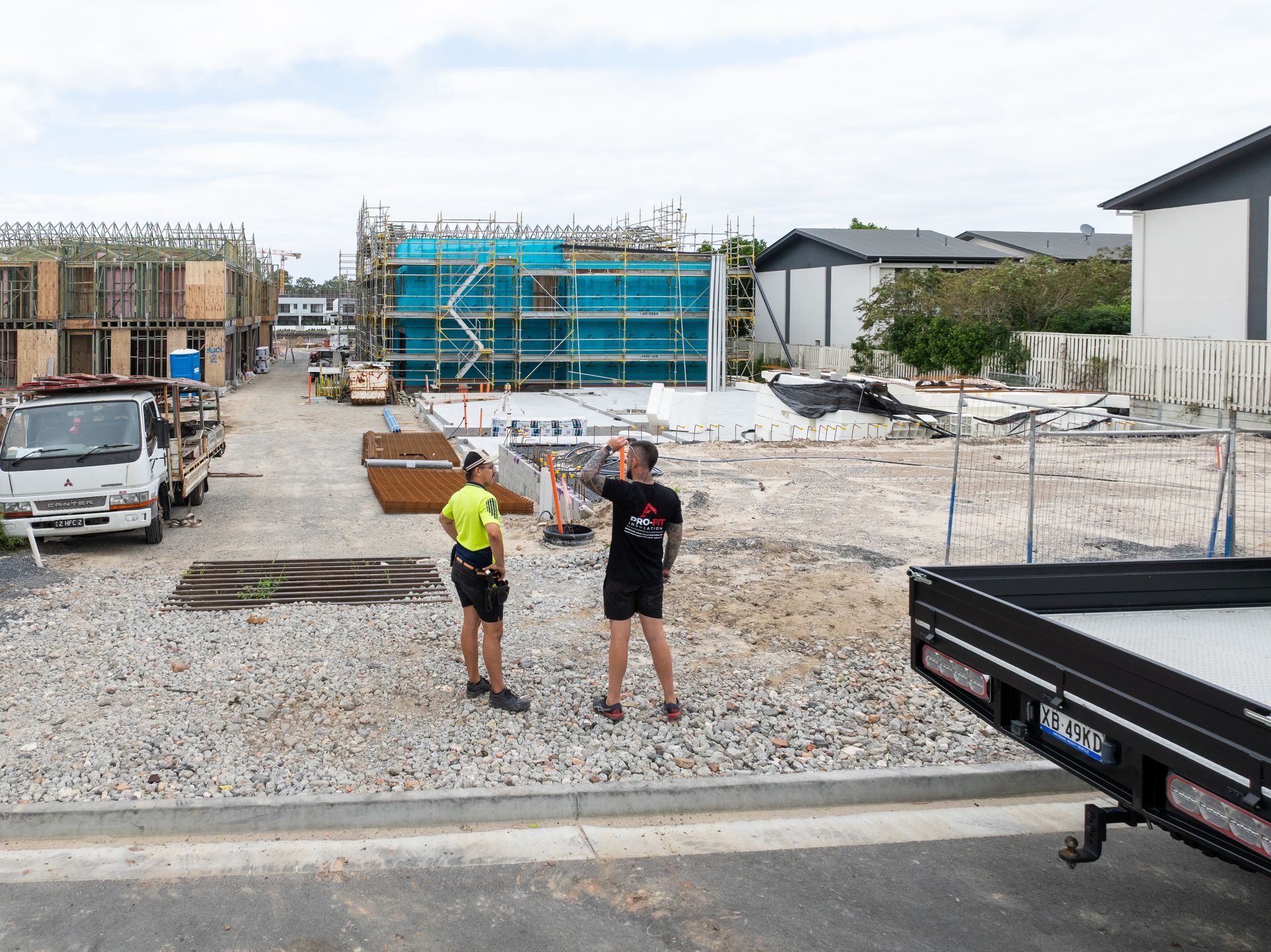 Two trucks are parked in front of a building — Home Insulation in Brisbane QLD