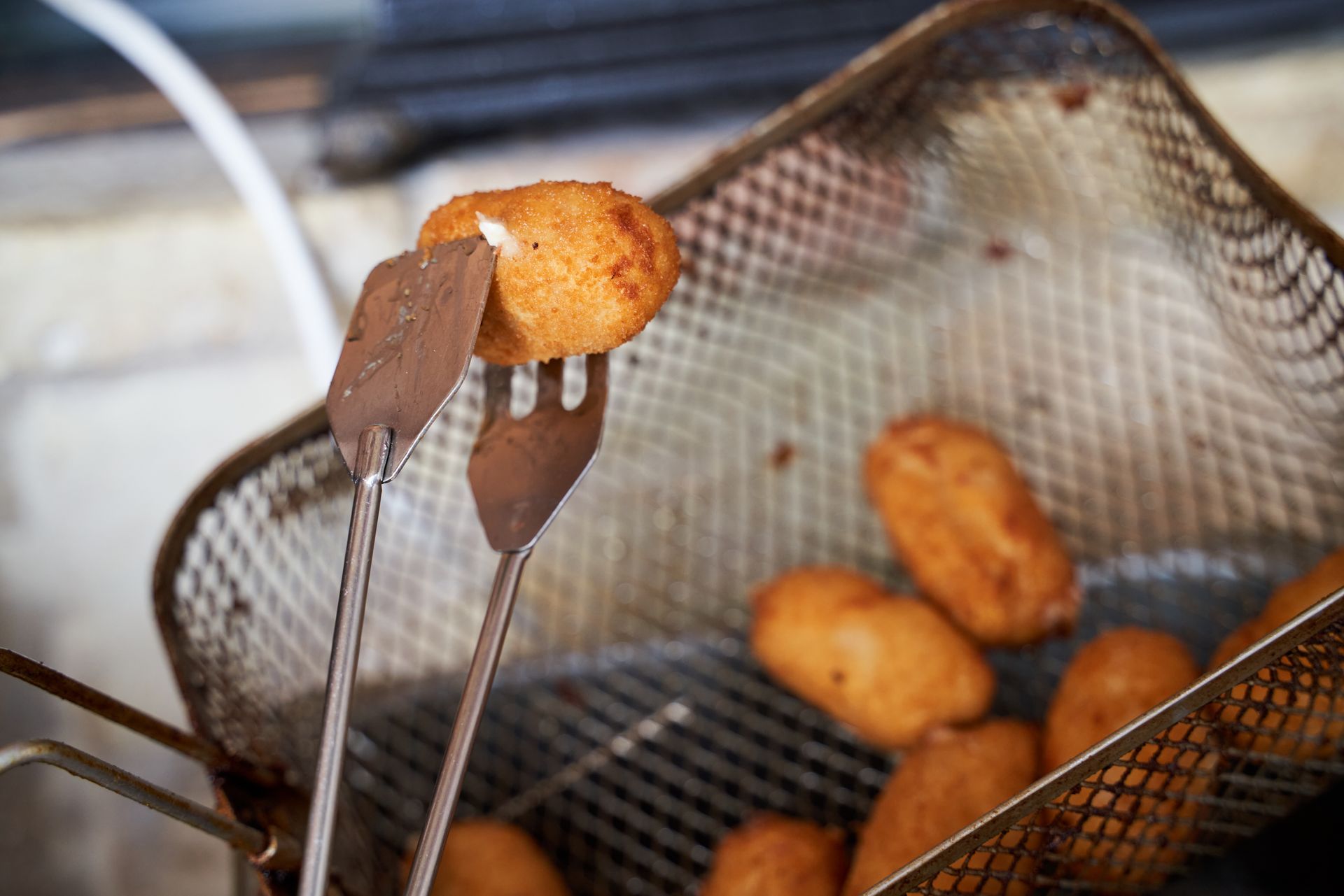 un cestino di fritture con dentro una pinza e una forchetta.