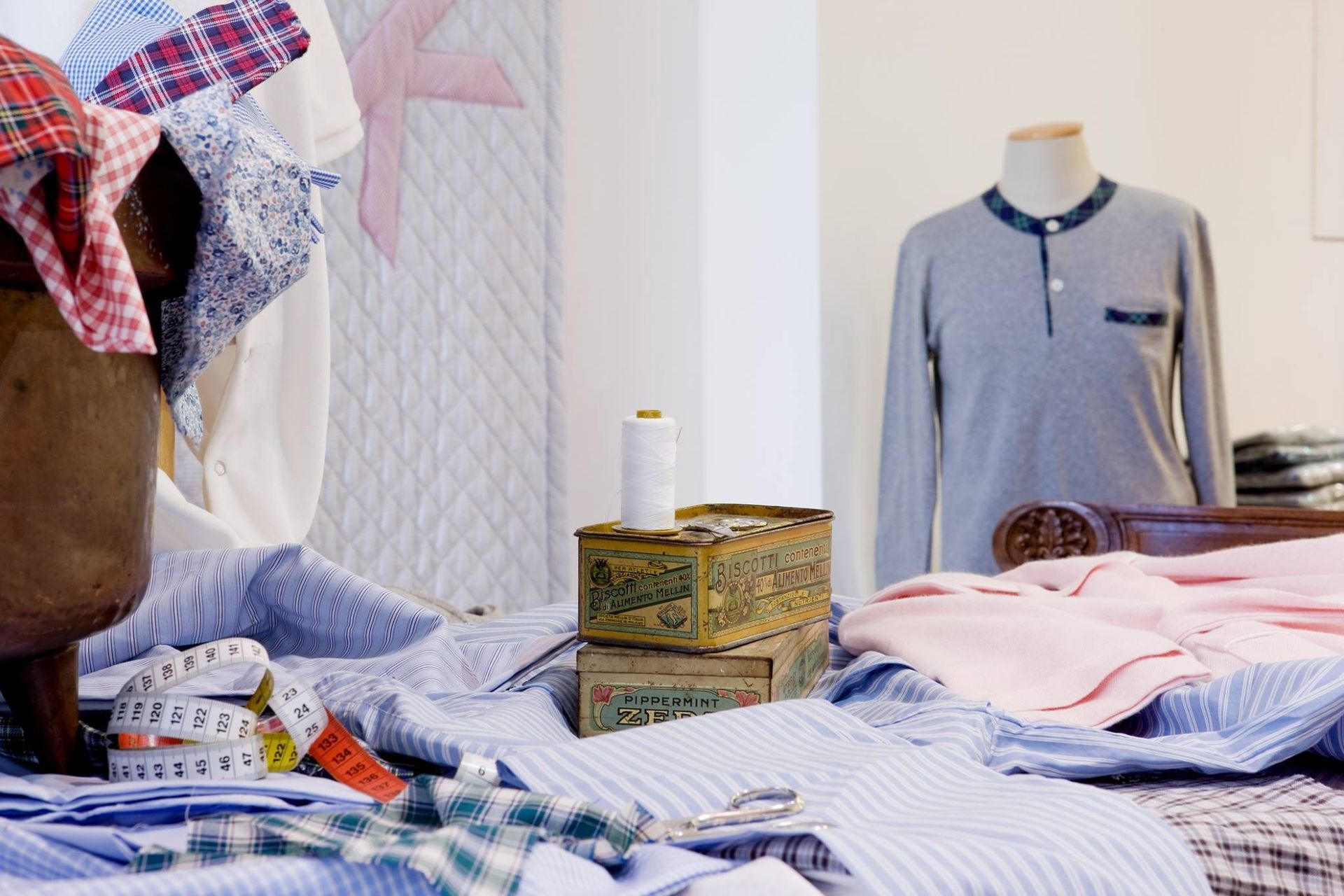 Cuscino beige su lenzuola bianche, angolo in primo piano.