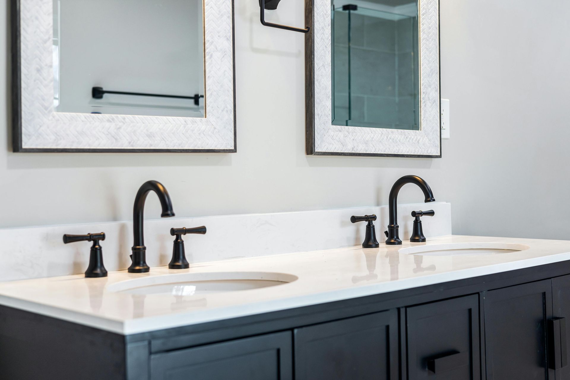 A double vanity with brushed chrome fixtures and dark blue cabinets