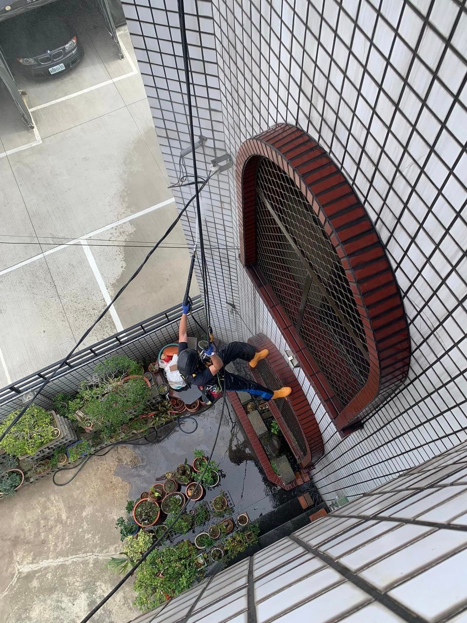 A man is cleaning a window on the side of a building.