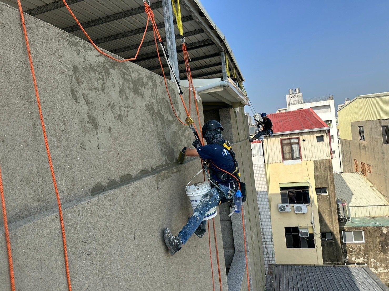 A man is climbing up the side of a building.