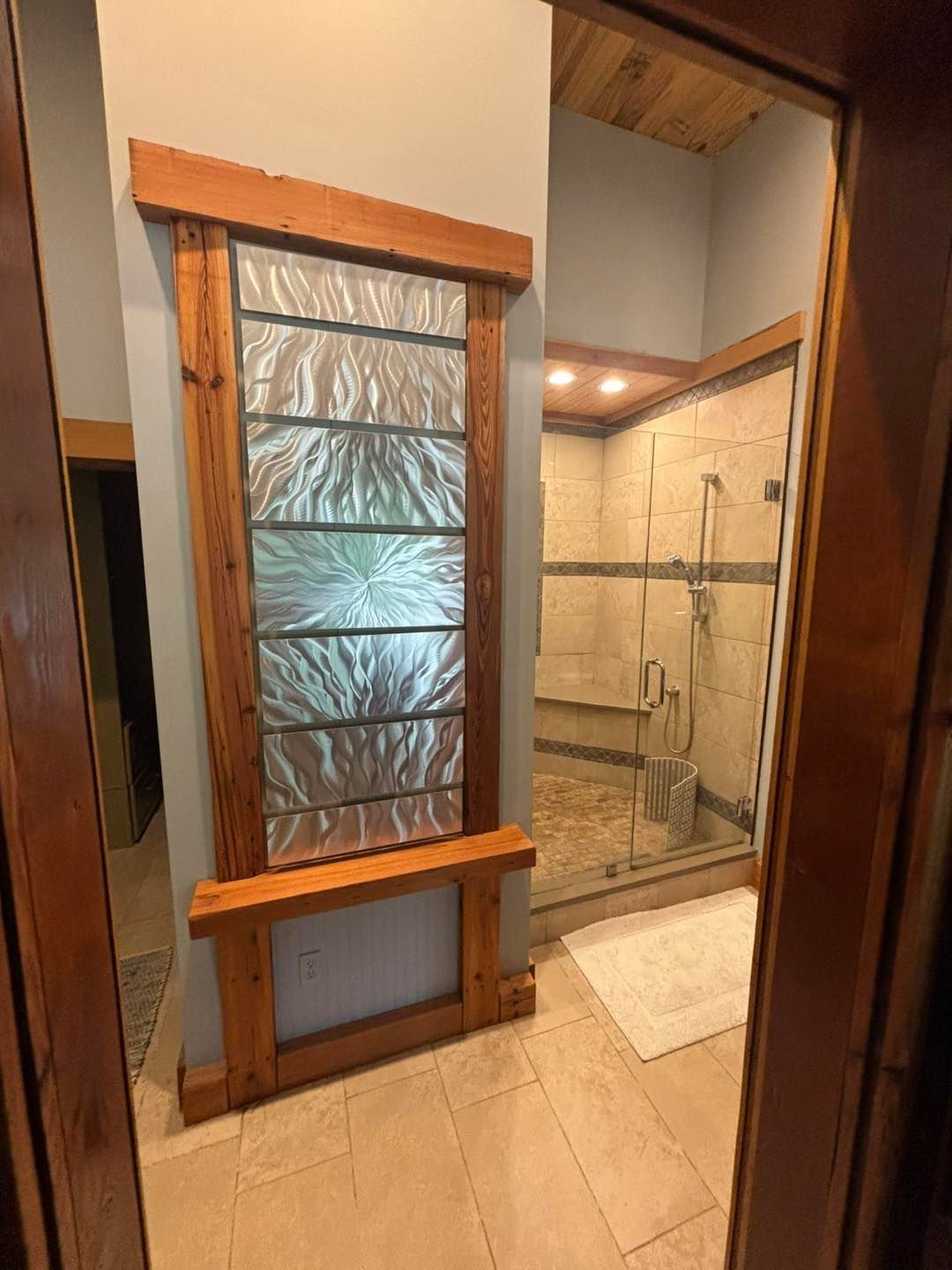 Bathroom with decorative glass blocks framed in wood, adjacent to a glass-enclosed shower.