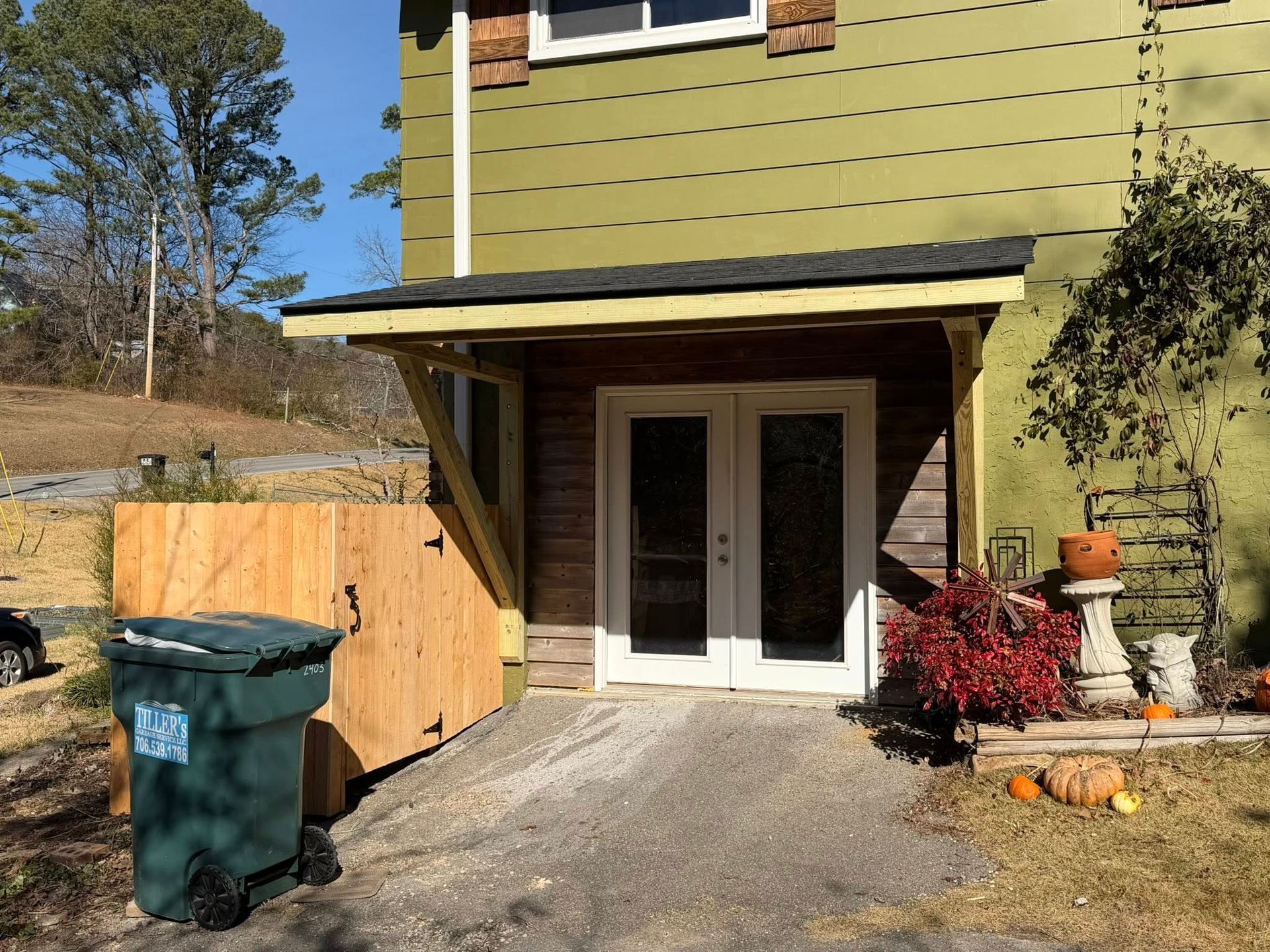 A modern bathroom featuring a dark vanity, a rectangular mirror, a glass-enclosed shower, and wood-look flooring.