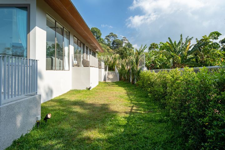 A large white house with a lush green lawn in front of it.