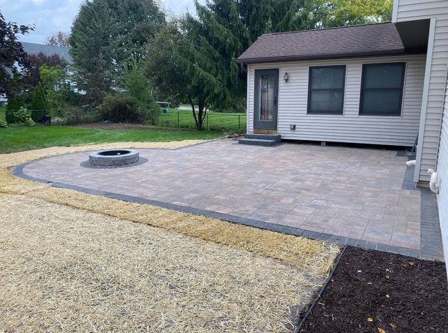 There is a fire pit in the backyard of a house.