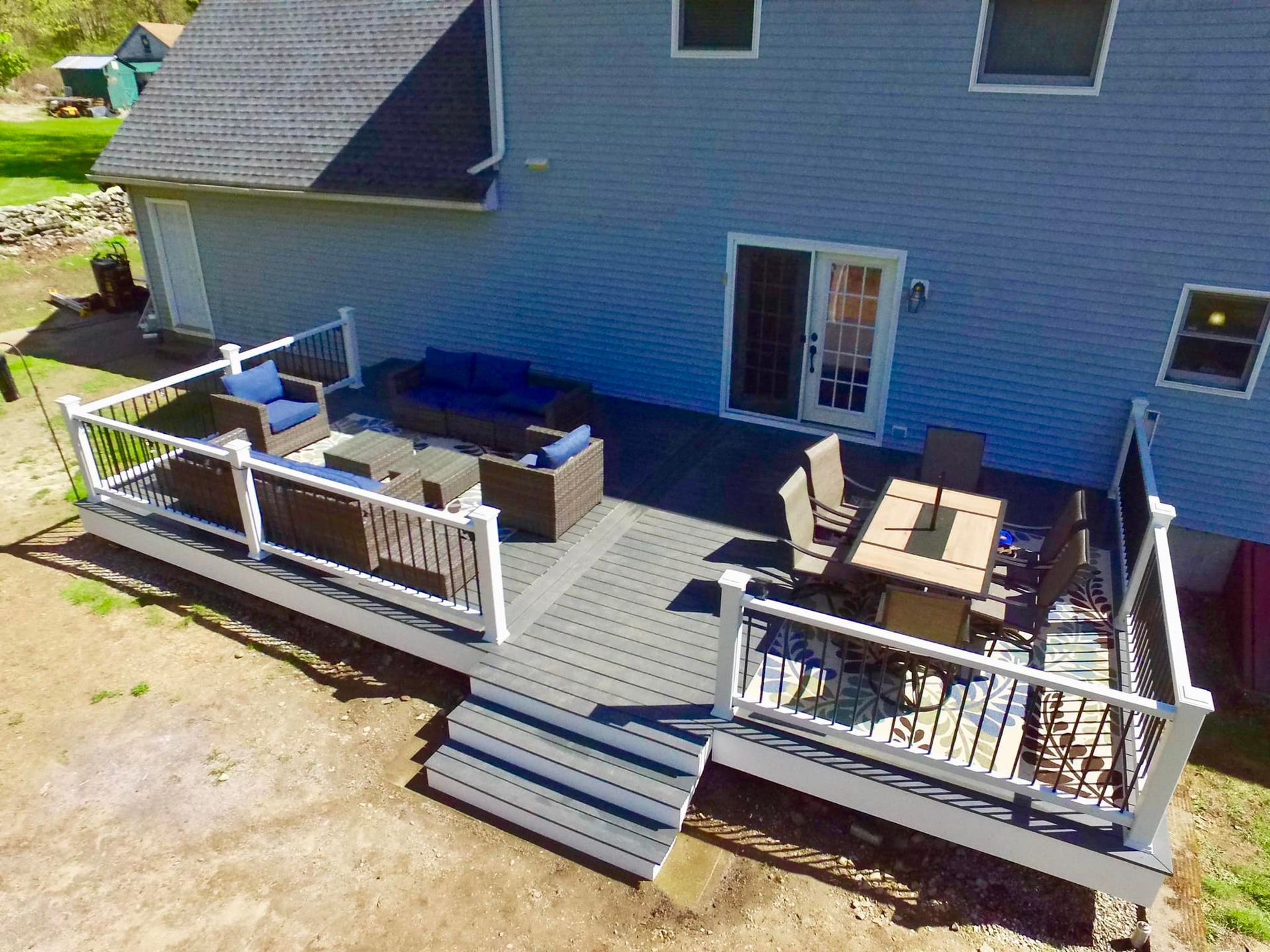 An aerial view of a large deck with a table and chairs in front of a house.