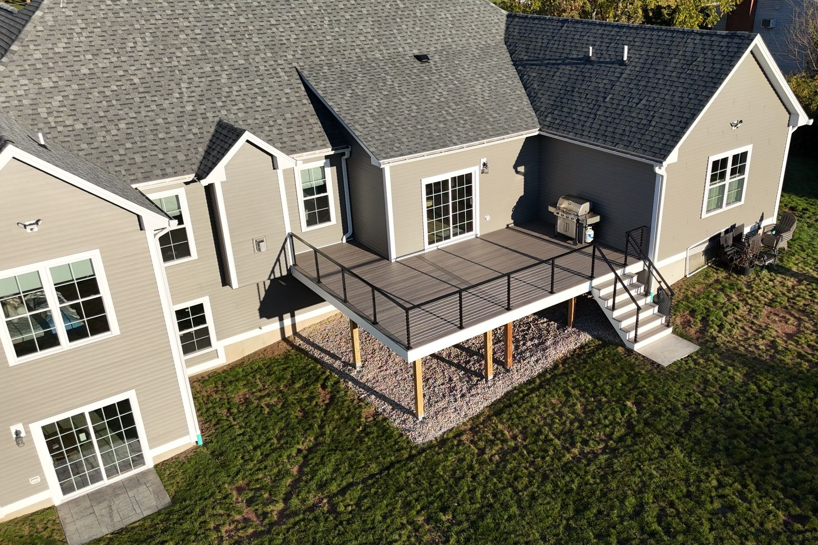 An aerial view of a deck with a table and chairs in front of a house.