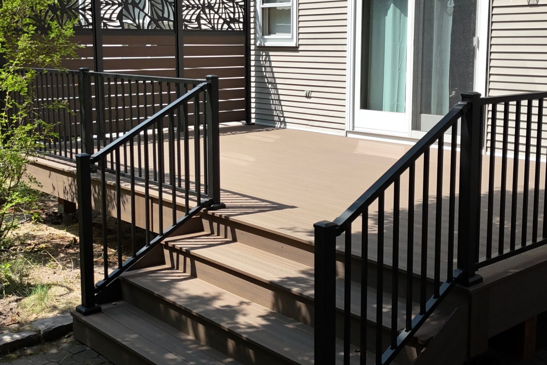 A deck with a white railing is covered in snow.