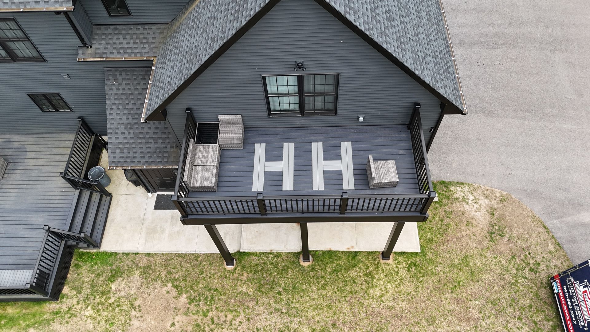 Aerial view of a gray house with a deck. 