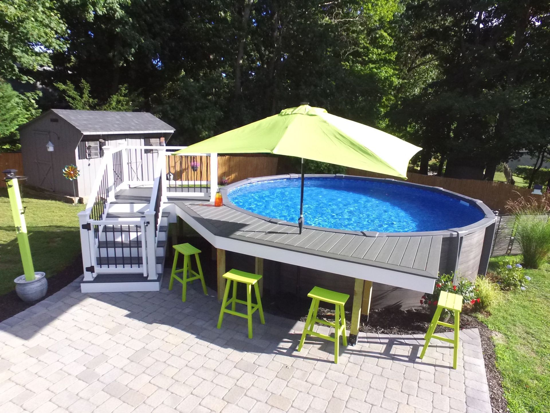 A swimming pool with a green umbrella on top of it