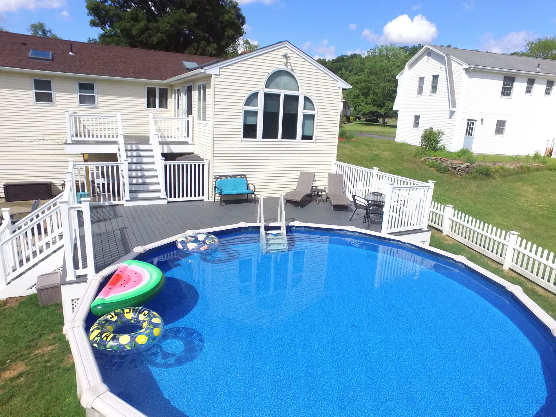 An aerial view of a swimming pool in front of a house.