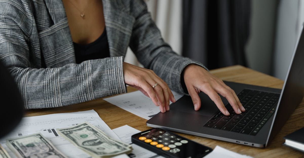 A woman is sitting at a table using a laptop computer.