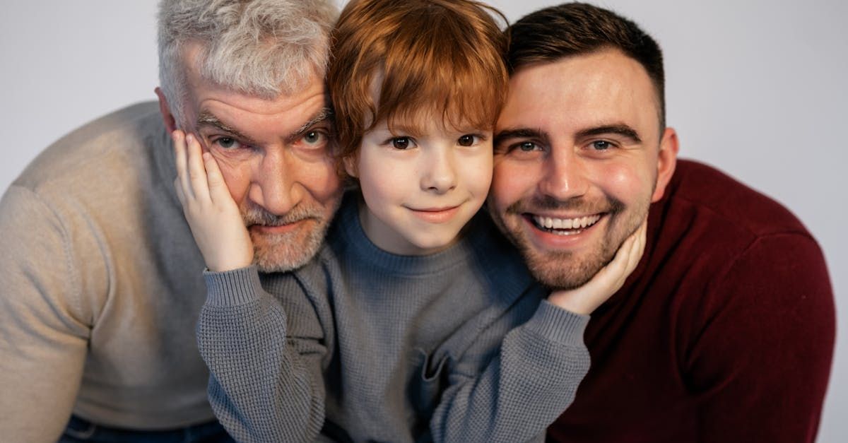Three men are posing for a picture with a little boy.
