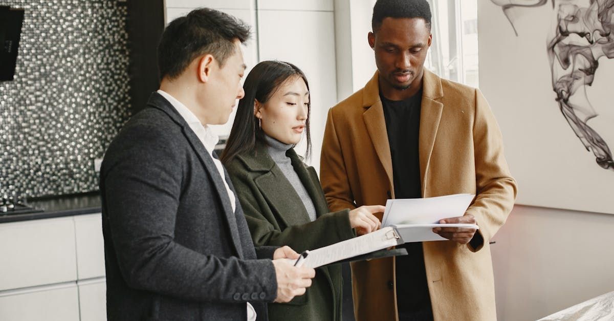A group of people are standing in a room looking at papers.