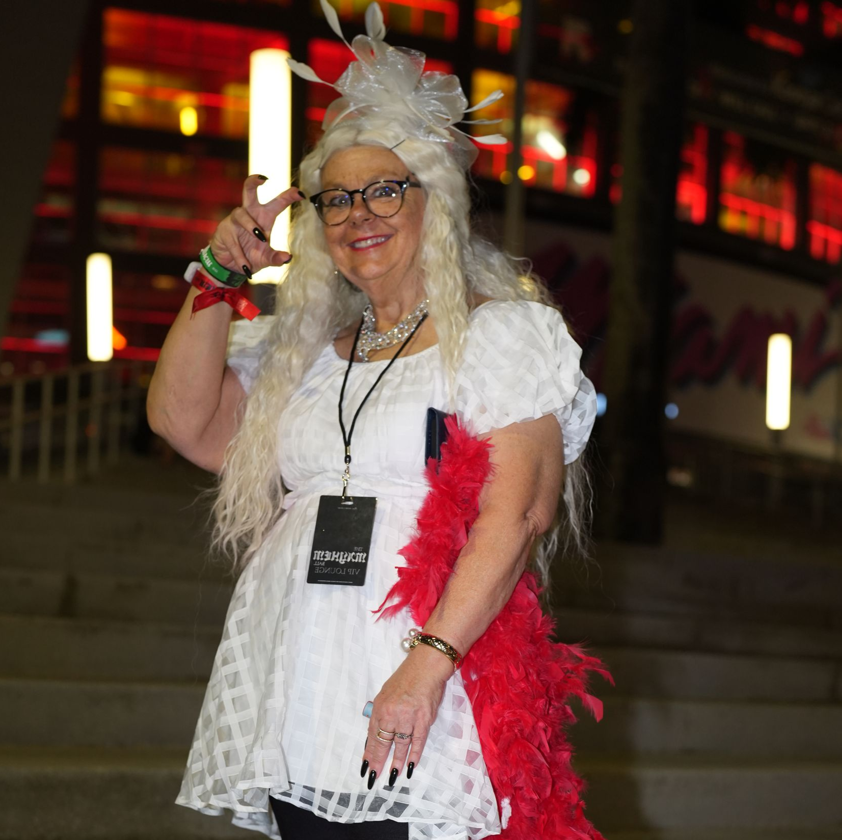 A young woman and older woman embrace on a basketball court. The younger woman wears a burgundy tank and white skirt, the older wears a tie-dye shirt.