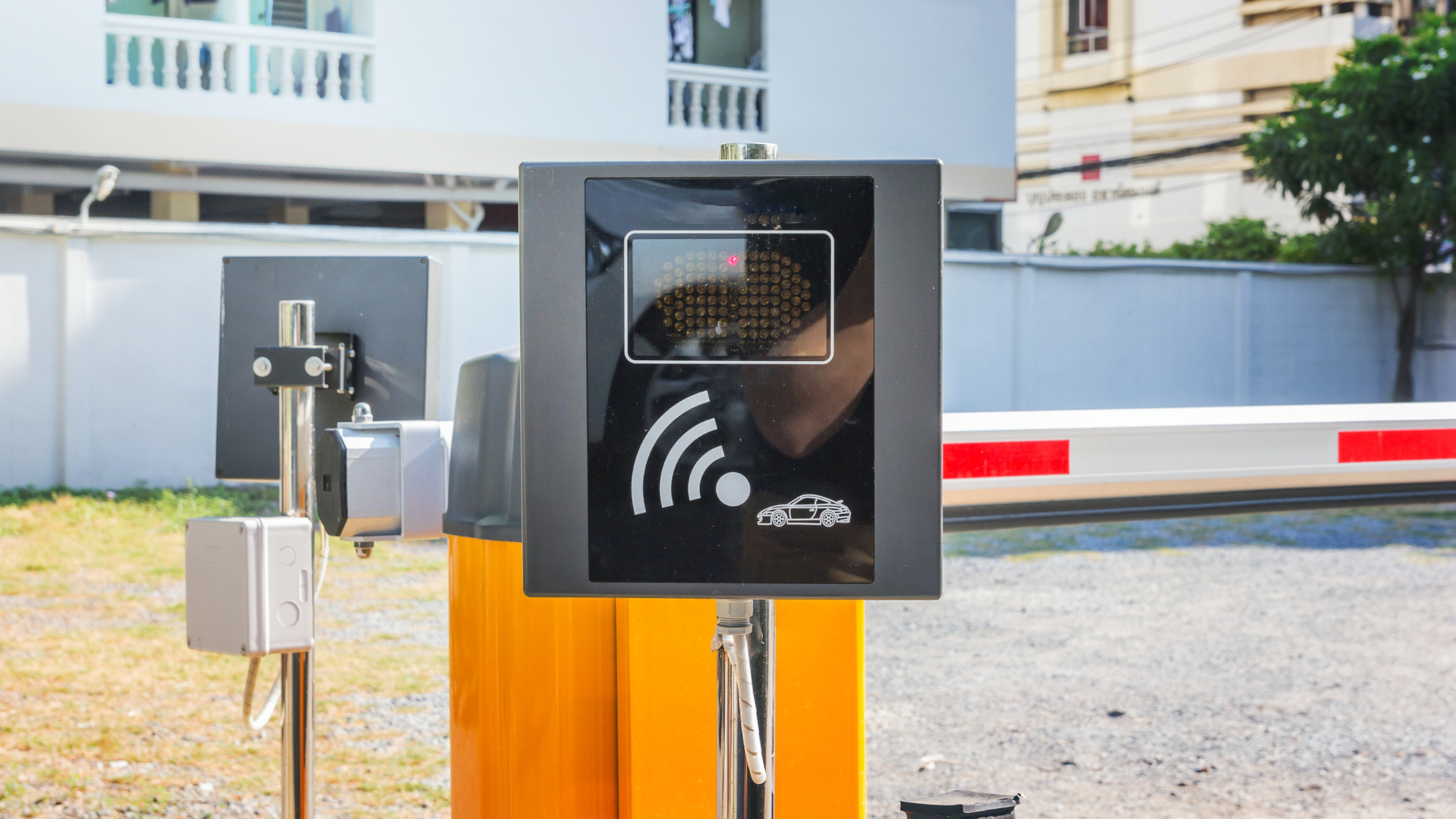 A close up of a parking gate with a car behind it.
