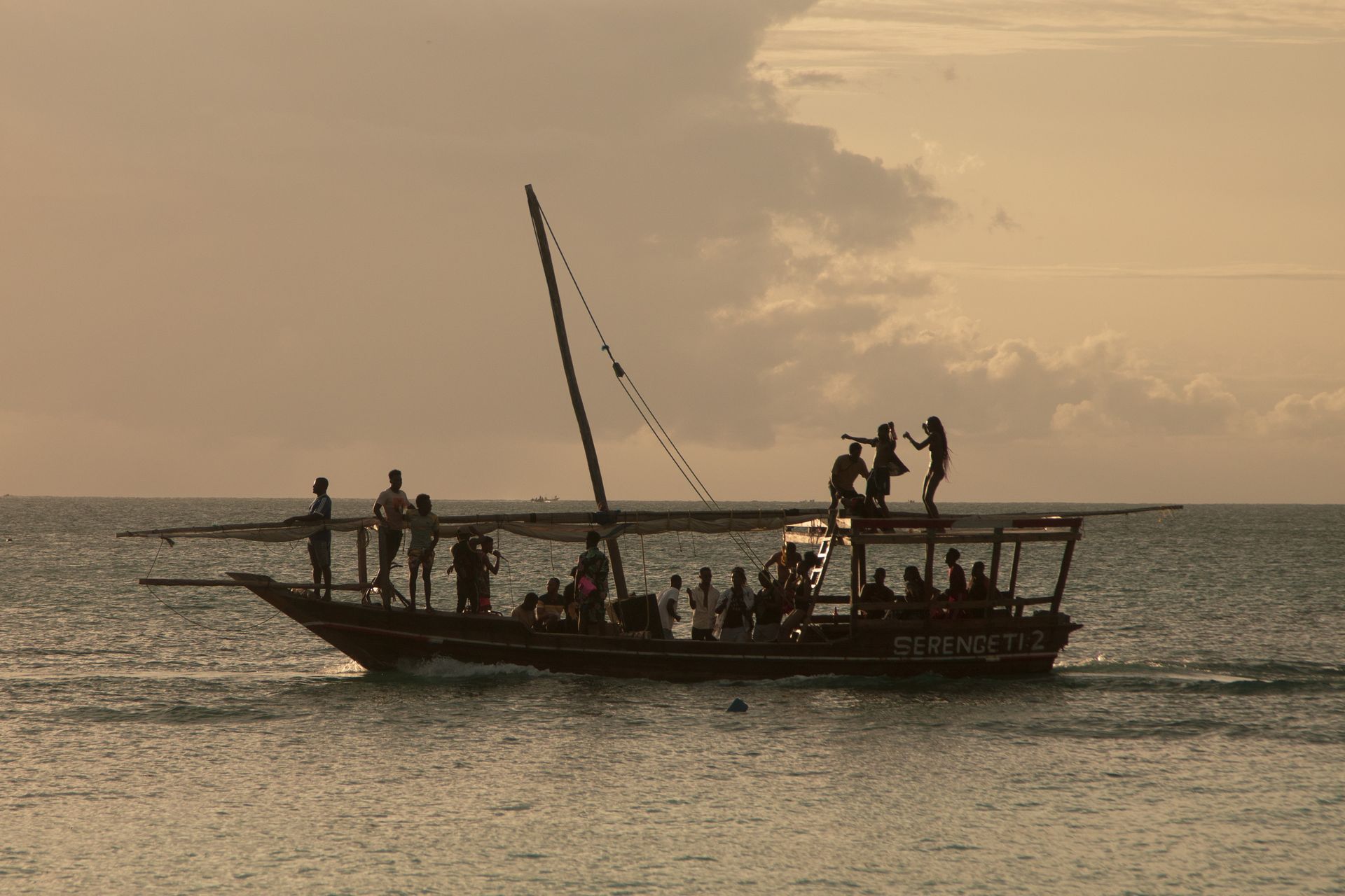 A boat filled with people is floating on top of a body of water.