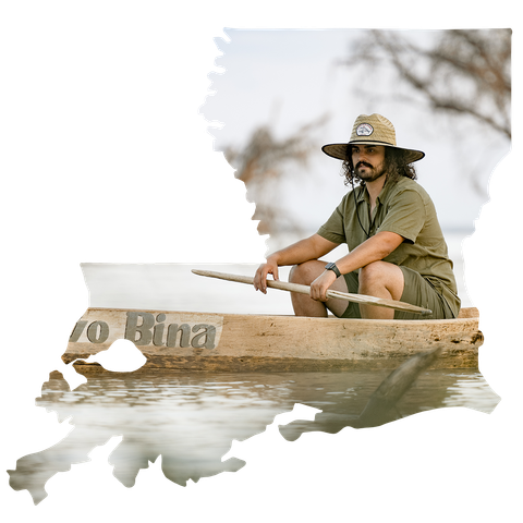 A man in a hat is sitting in a boat that says binna