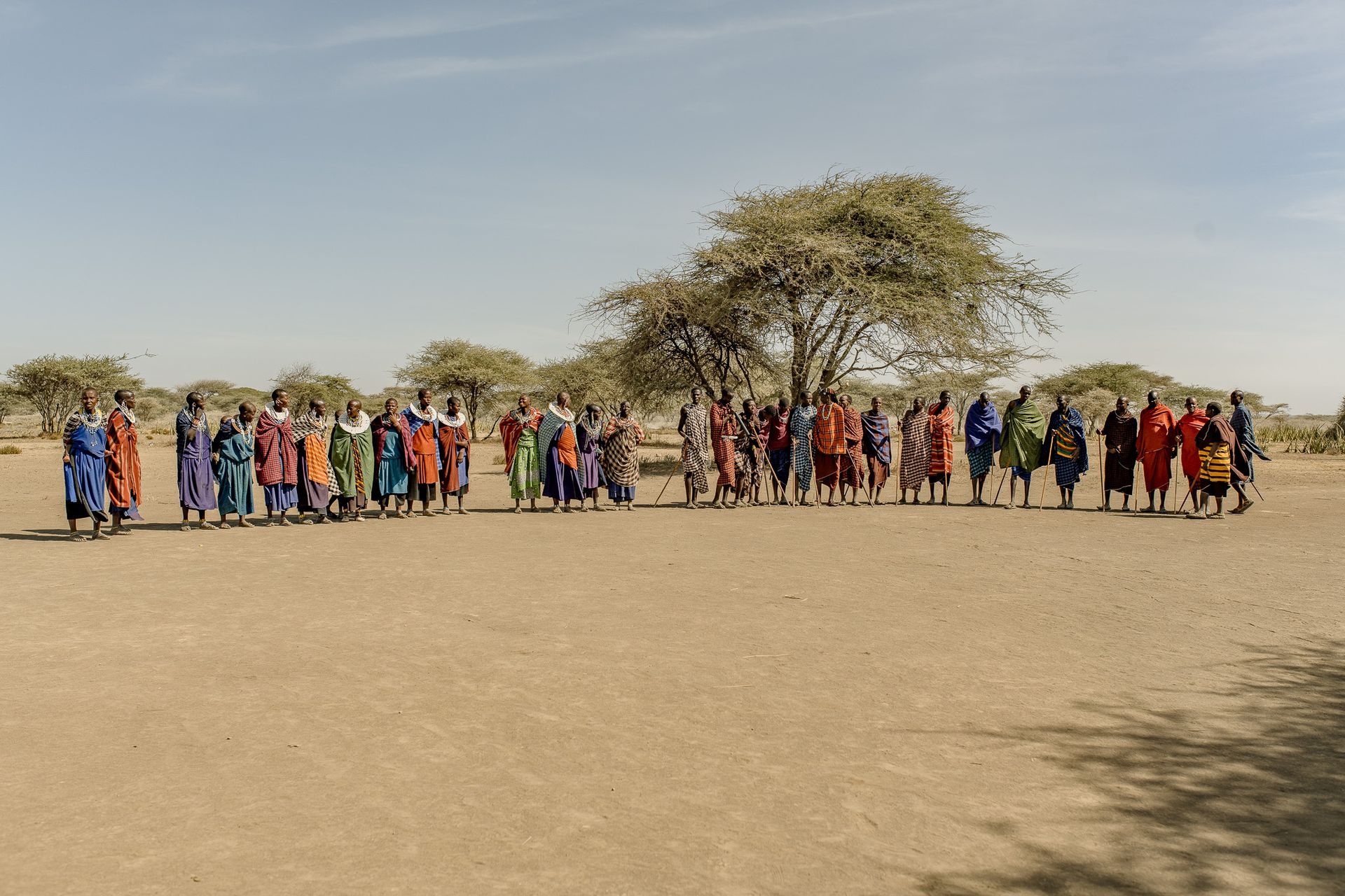 A group of people are standing in a circle in the desert.